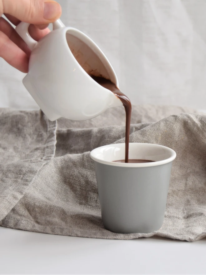 Pouring thick vegan-friendly hot chocolate into cup