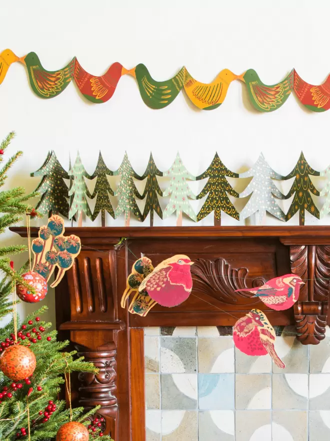 Christmas layout of garland hanging over fireplace along with 2 other Christmas garlands