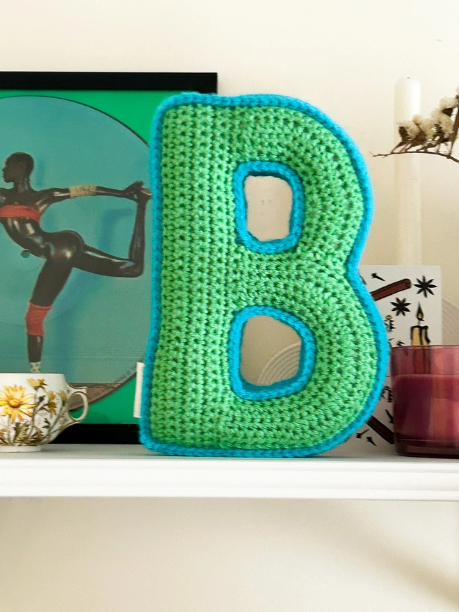 Crochet cushion in the shape of the letter B in green and blue