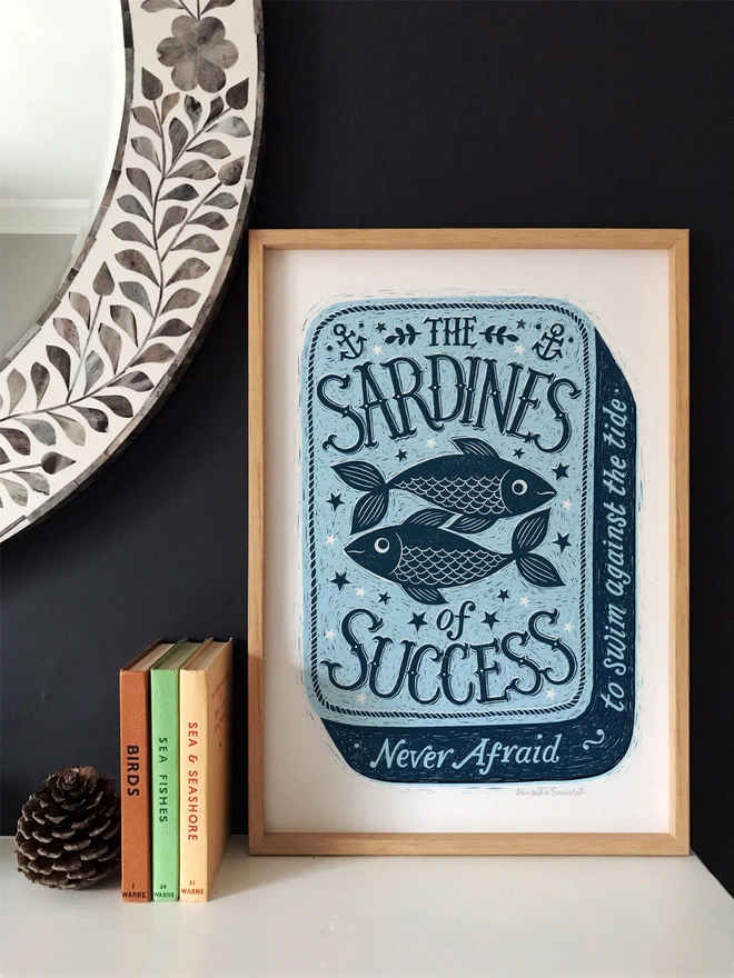blue sardine tin print in wood frame on shelf