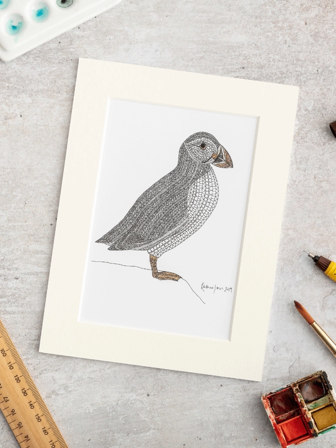 Print of an intricately patterned pen and watercolour drawing of a Puffin bird, in a soft white mount