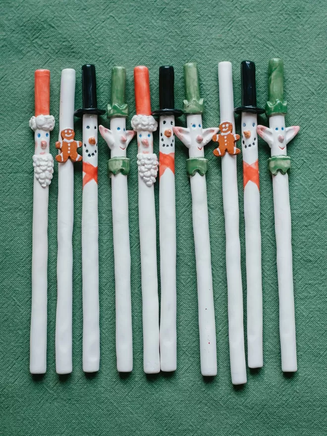 Bill and Ben Christmas straws seen laid out on green fabric.