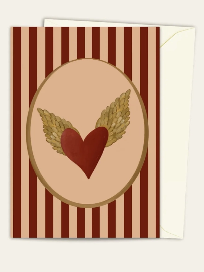 Winged Heart Card, a colourful card sitting on a plain white surface on top of its envelope.