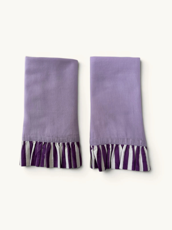 Pair of Ruffle Napkins. A pair of napkins, folded, in lavender and violet.