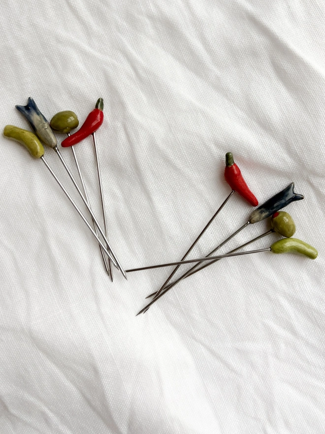 two sets of 4 cocktail sticks on a white cloth