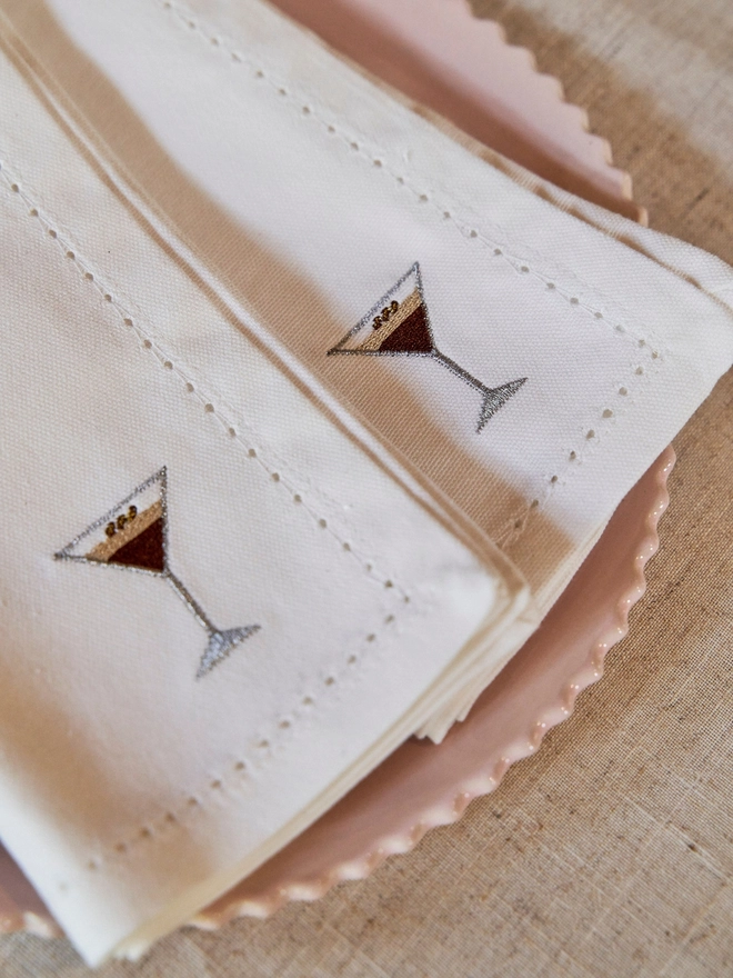 A white napkin with an espresso martini embroidered motif