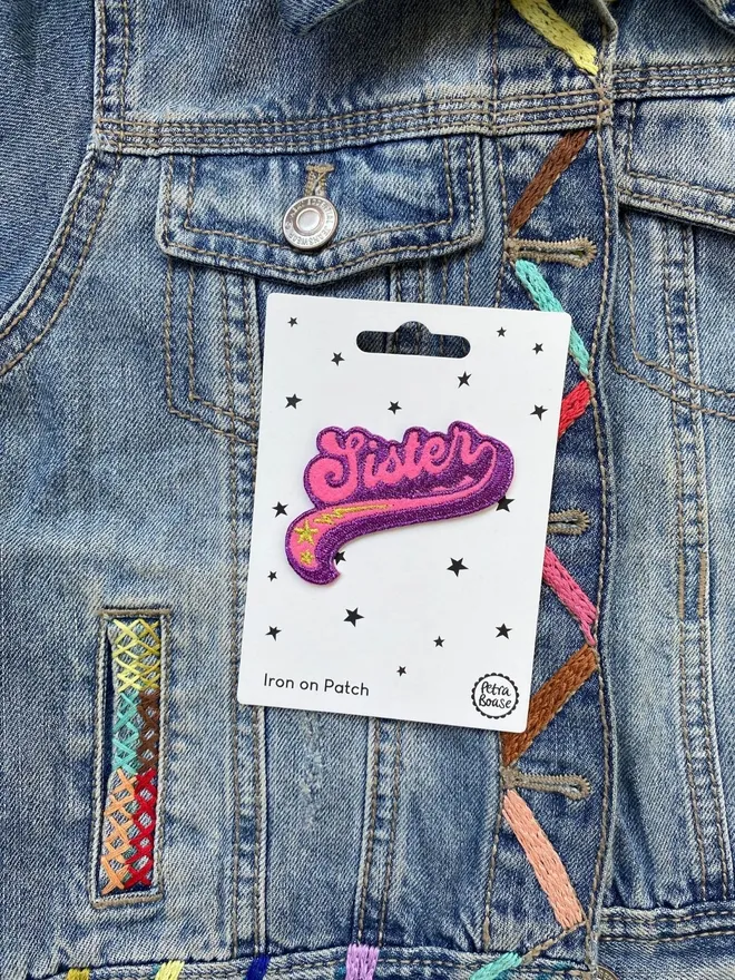 Sister embroidered iron on fabric patch on a kids embroidereddenim jacket.
