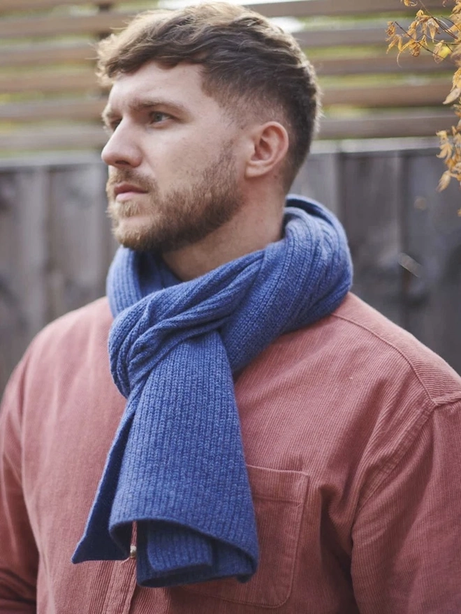 Lambswool Ribbed Scarf, a man wearing a colourful ribbed scarf outdoors. 