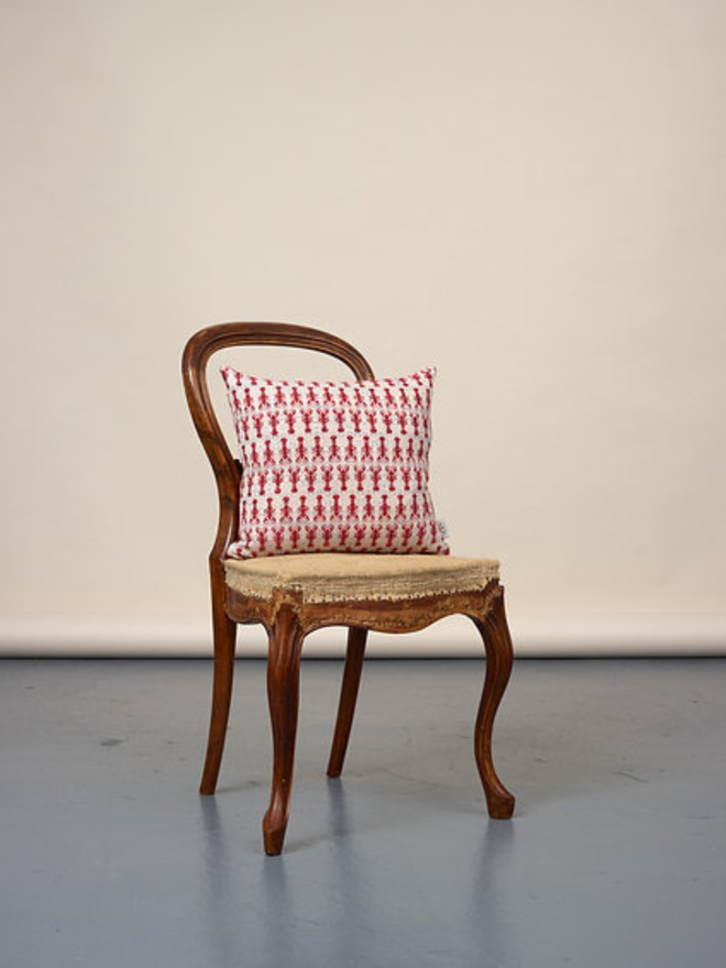 lobster square cushion. a square cushion embroidered with lobsters photographed on a chair. 
