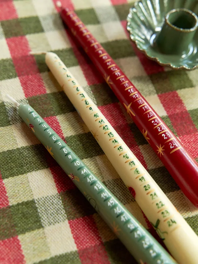 '24 Nights To Christmas' Advent Candle placeed on a checkered red and green tablecloth