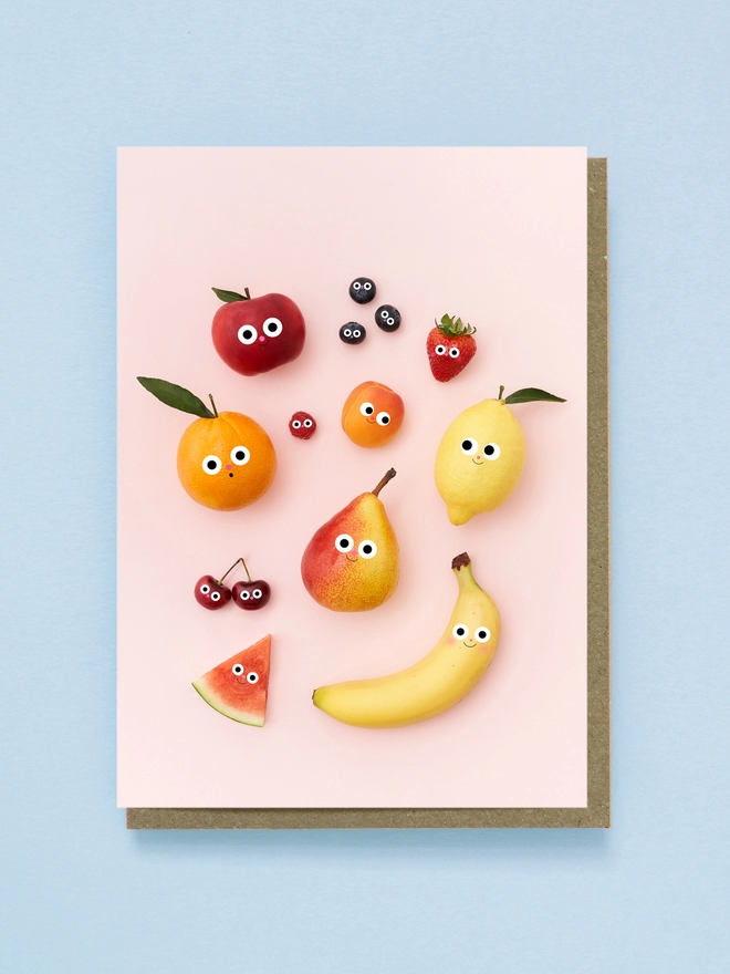 A gang of friendly fruits greetings card on a pink background 