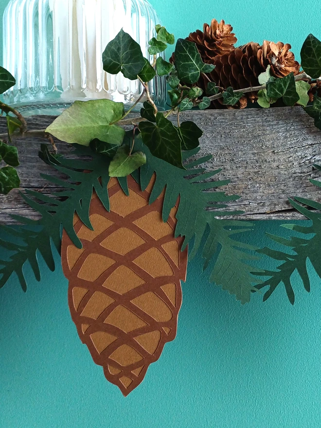 Closeup view of large paper pinecone decoration with dark green spruce