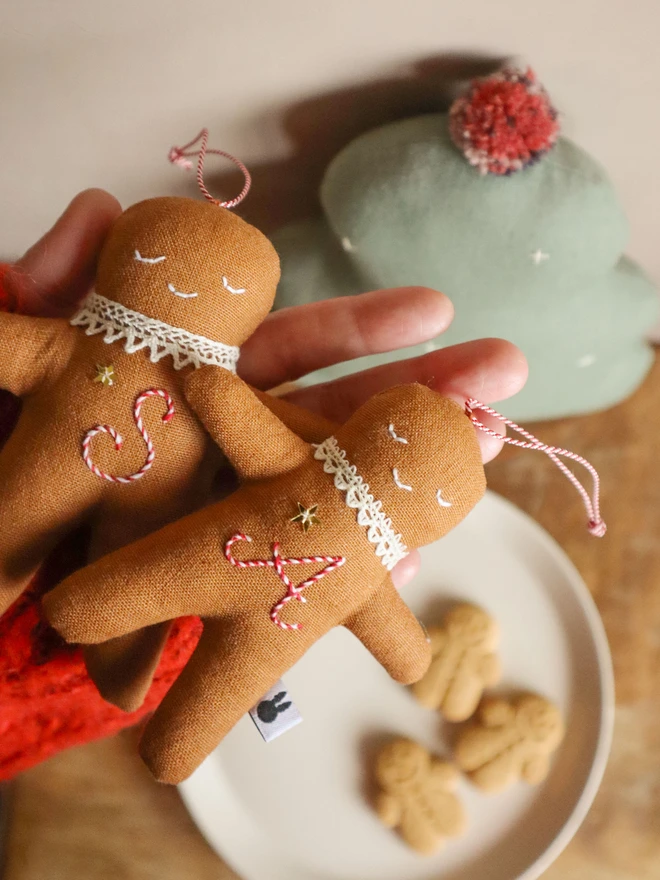 christmas tree ornament with a letter hand embroidered in candy cane colours, star shaped sequin, crochet cotton lace around the neck, smile embroidered in white and candy cane colour string to hang.