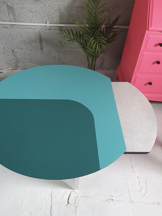 Design painted in teal and turquoise on extended round coffee table