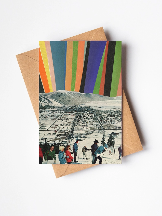 A Christmas card featuring a group of skiers enjoying the view of the northern lights.