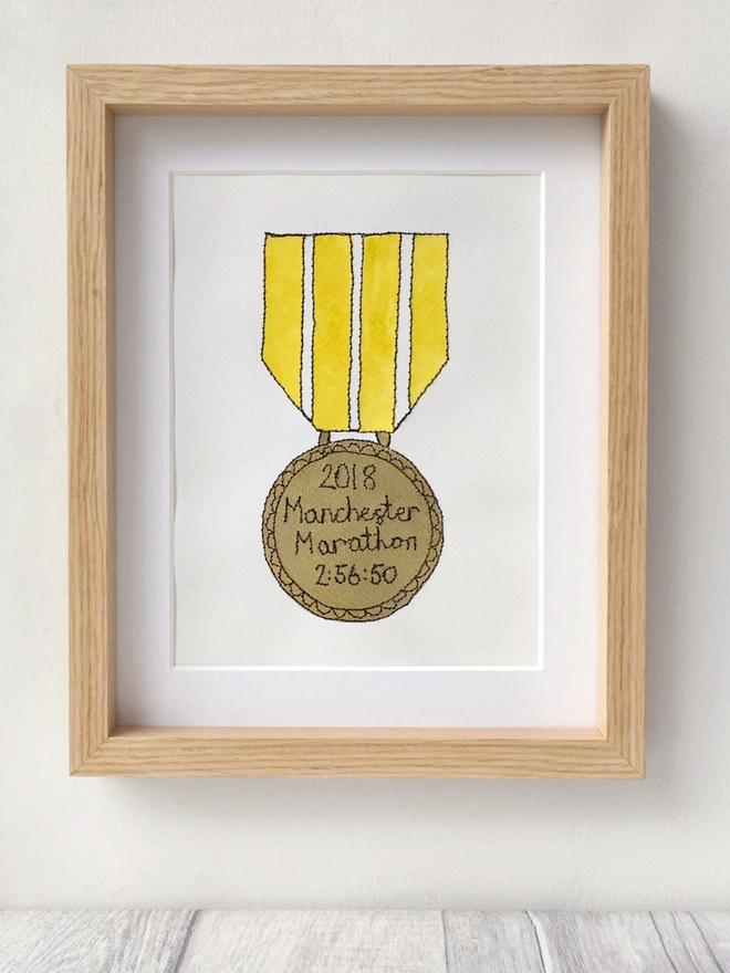 A hand painted gold medal with an embroidered personalised message  
