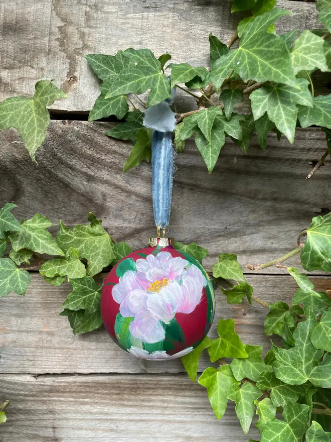 Hand painted floral bauble maroon background adorned in delicate pink peony flowers