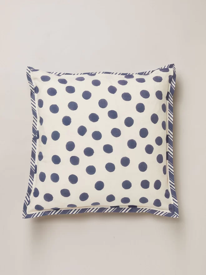 Back of block printed cushion featuring a navy dot onto a cream ground and trimmed in a navy and cream stripe border design