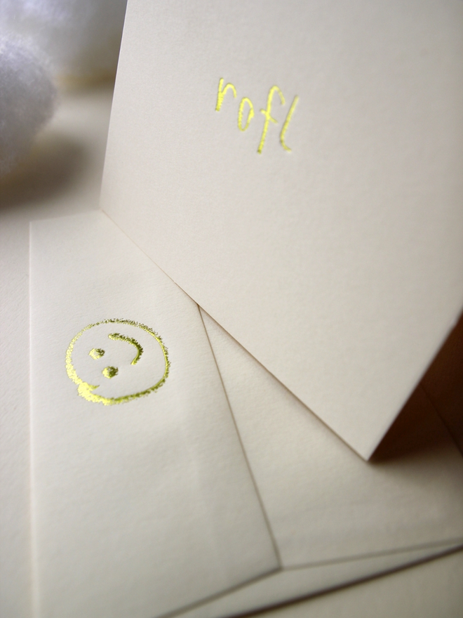 sandy coloured card with rofl short for 'roll on floor laughing' hand foiled in kids hand writing