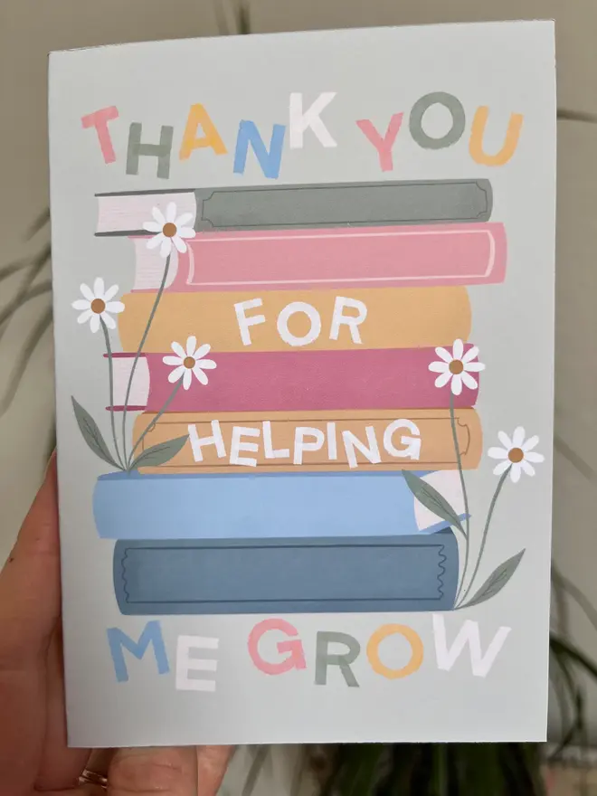 'thank you for helping me grow' illustrated card. green card with illustrated books and flowers.