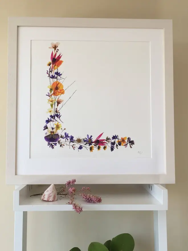 Pressed Wildflower Letter Print, a wildflower alphabet letter print sitting framed. 