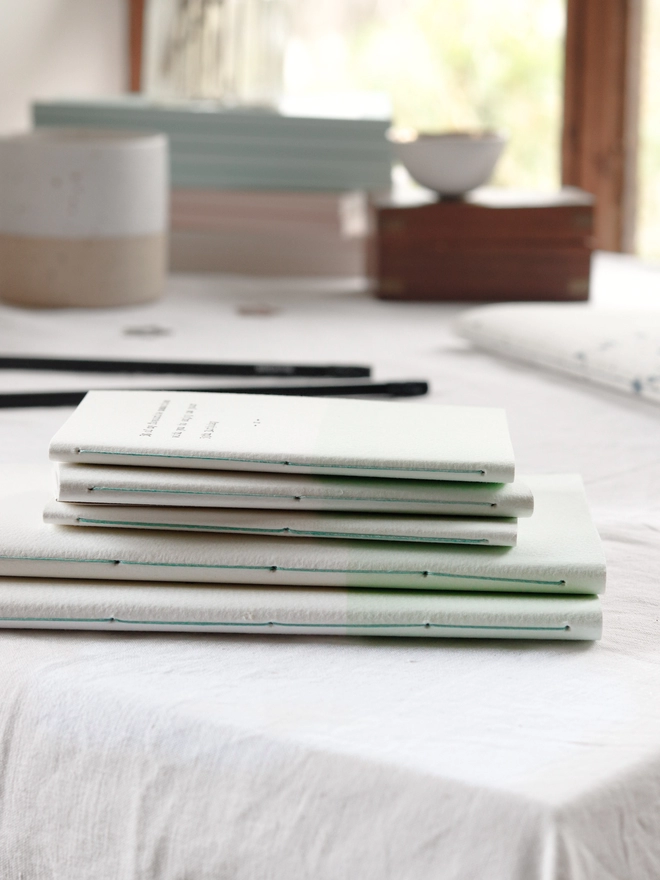 hand stitched notebook spines with green thread