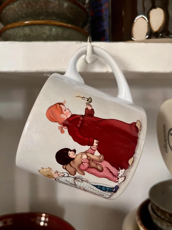 a childs mug featuring storybook style illustrations of children heading to bed soooo cosy