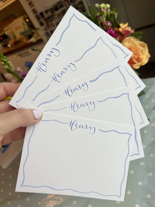 Five white notecards with Henry written in dark blue calligraphy at the top and a pastel blue wavy border around the edge of the card.