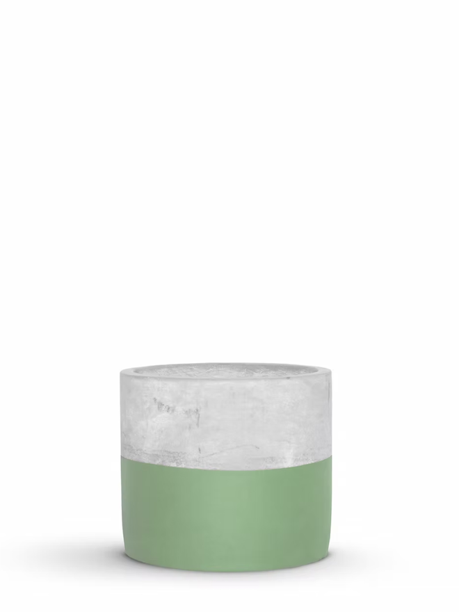 half full concrete plant pot. a grey concrete plant pot with the bottom half painted green.