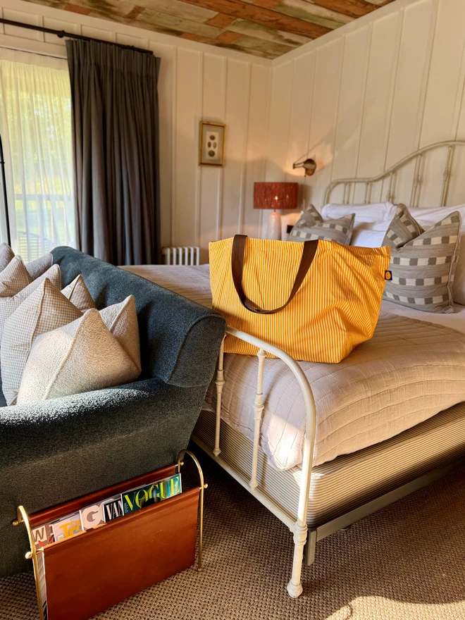yellow stripey overnight bag on bed 