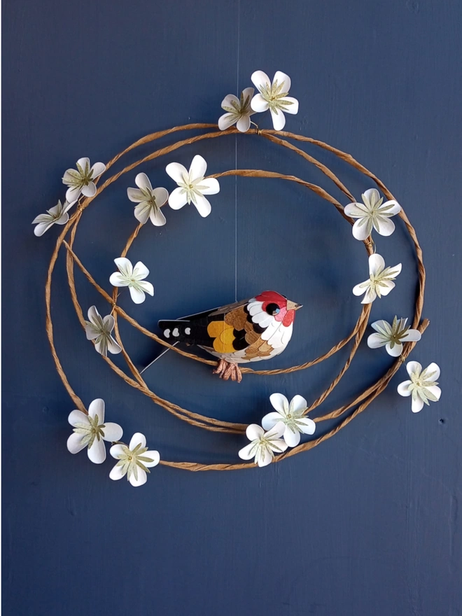 Goldfinch sculpture on a white blossom wreath