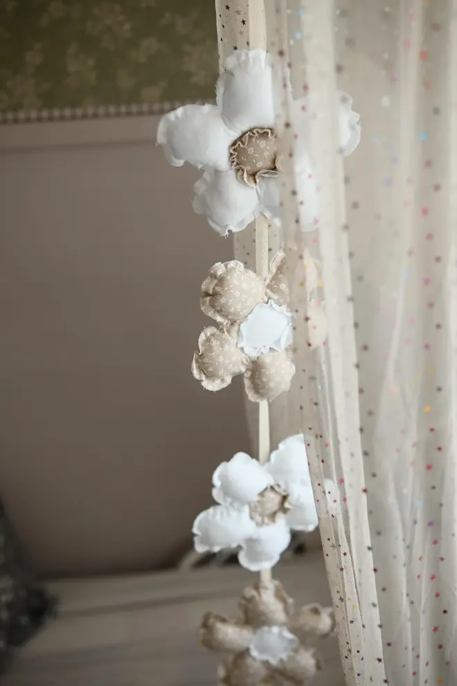 Daisy Flower Garland Decoration, a hanging colourful daisy flower garland sitting in a child's bedroom. 