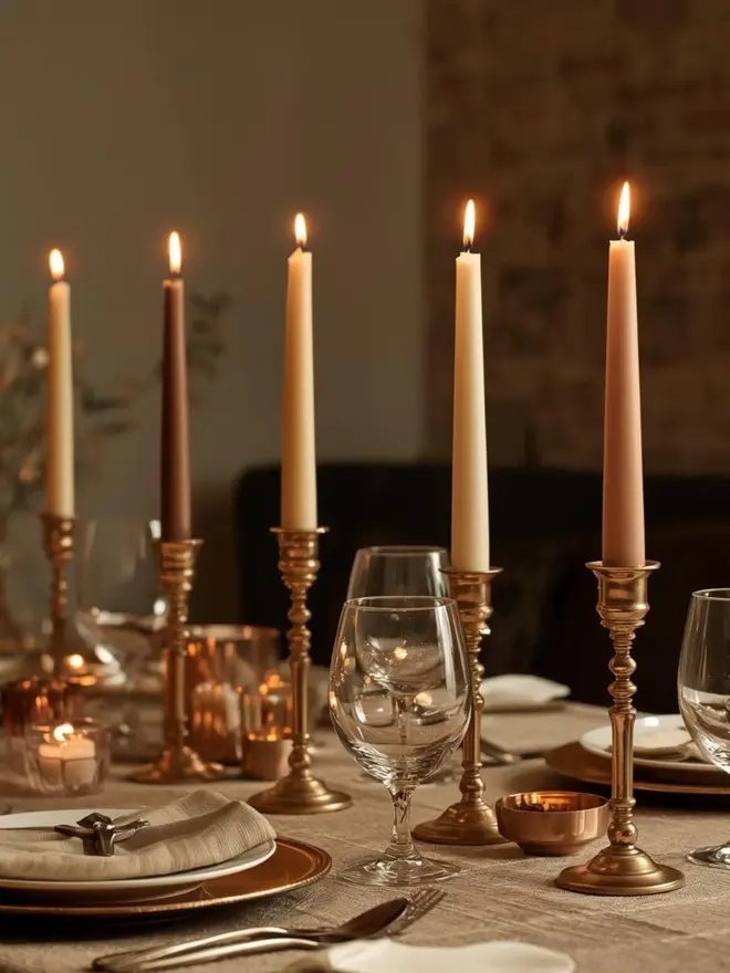 Lifestye image of latte dinner candles on a laid table with wine glasses and plate