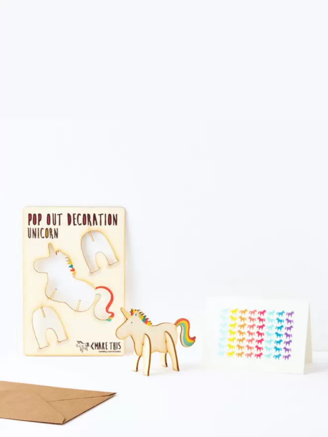 Rainbow unicorn decoration and unicorn pattern greeting card and brown kraft envelope on a white background