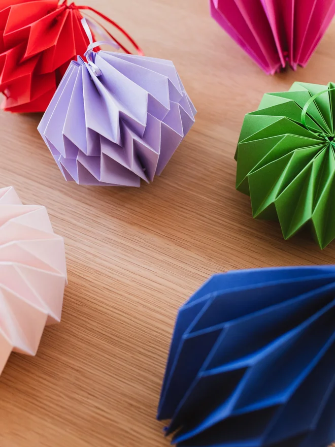 Colourful paper origami shapes scattered on a table.