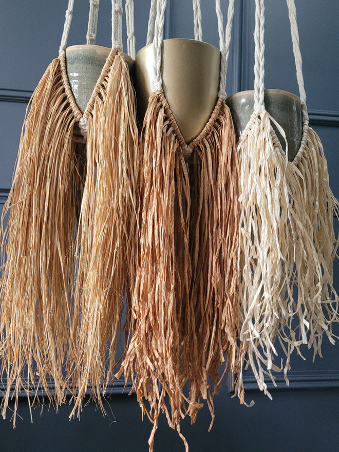 Handmade unique macrame raffia paper plant hanger, full of natural texture and movement, perfect for showcasing indoor plants and enhancing home decor