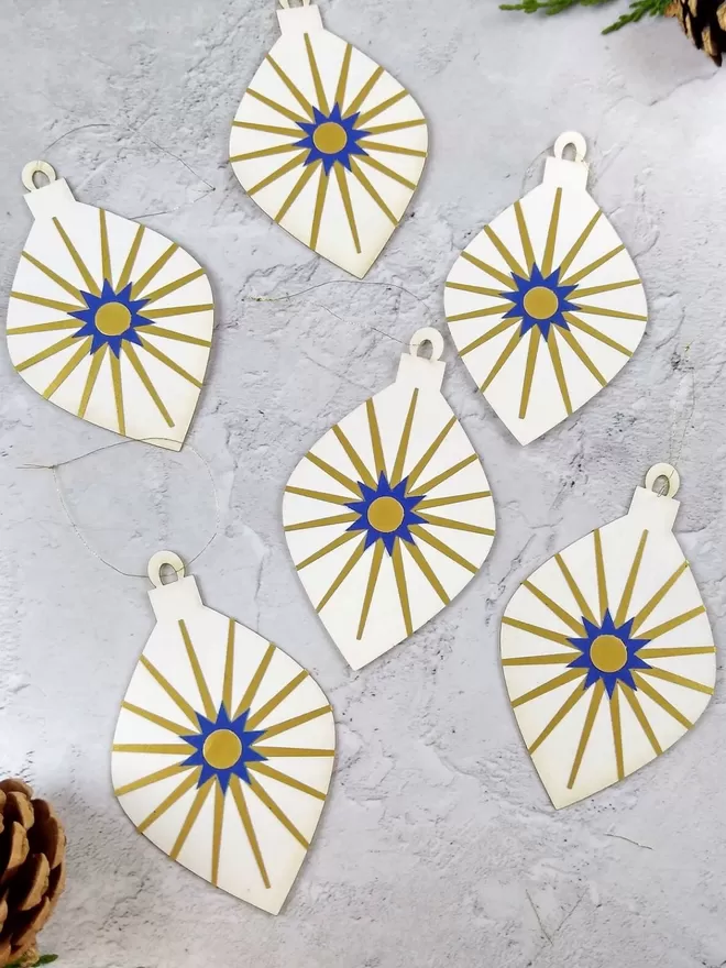 6 white pendant shaped paper baubles. Each has a gold  and blue starburst decoration.Gold Starburst Pendant Paper Christmas Decorations