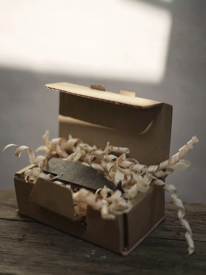 Whale Bottle Opener, a whale shaped bottle opener sitting in its packaging. 