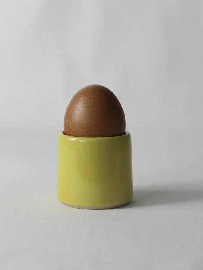 Classic Handmade Egg Cup, a ceramic egg cup sitting on a plain surface against a white backdrop. 