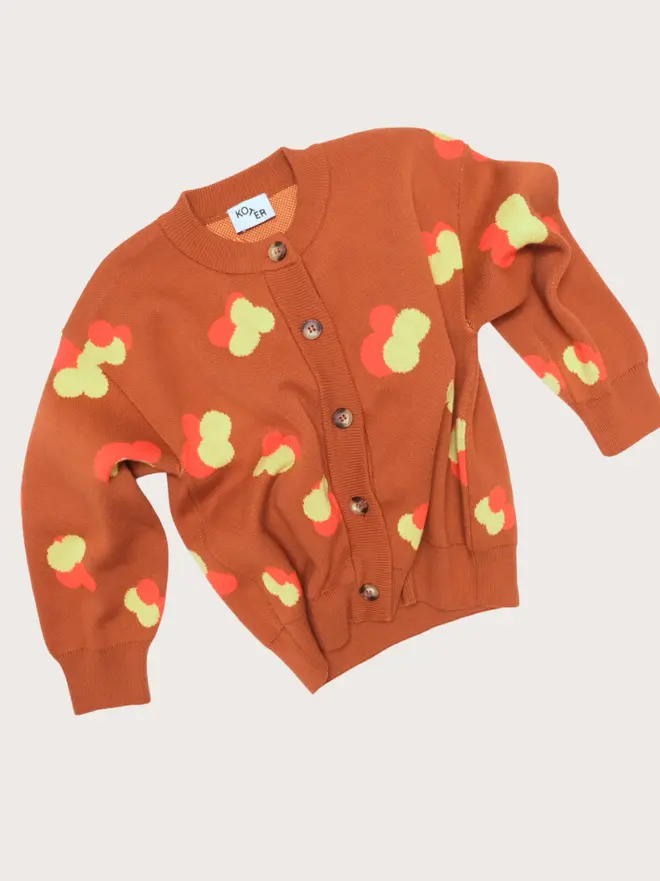 Front flat lay of the Studio Koter Finneas cardigan, a chestnut jacquard knit with yellow and orange floral motif and buttons.