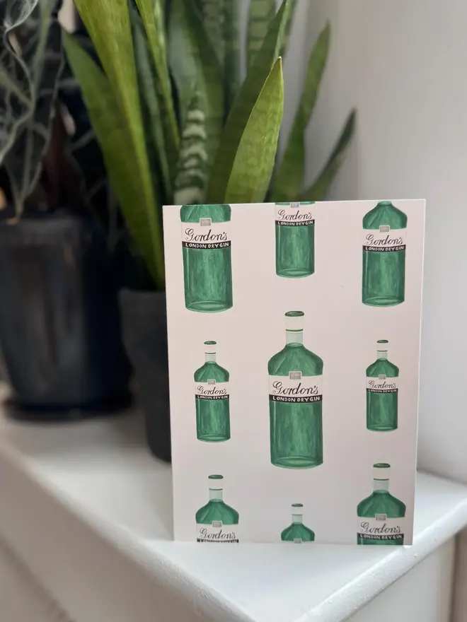 gin bottles illustrated card. card photographed on mantelpiece.