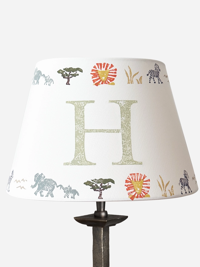 Studio Zef product image of a personalised kids safari lampshade with letter H. Empire lampshade featuring safari animals, perfect as a boys lampshade, kids lighting or presents for new parents.