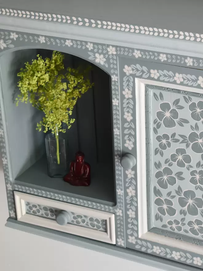 blue hand painted folk art cupboard with floral detailing