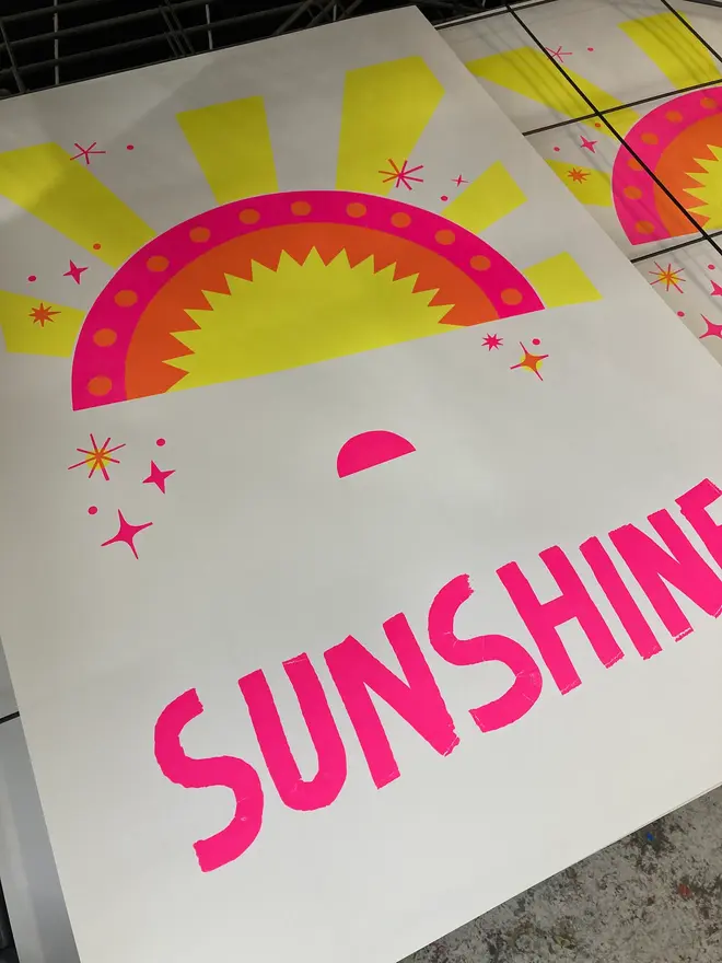 'Dial S For Sunshine' Screenprint, a colourful screenprint sitting in a studio rack in a pile. The screenprint reads 'Dial s for sunshine'. 