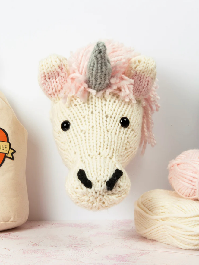 Unicorn Head Knitting Kit. A giant unicorn head in cream and pink.