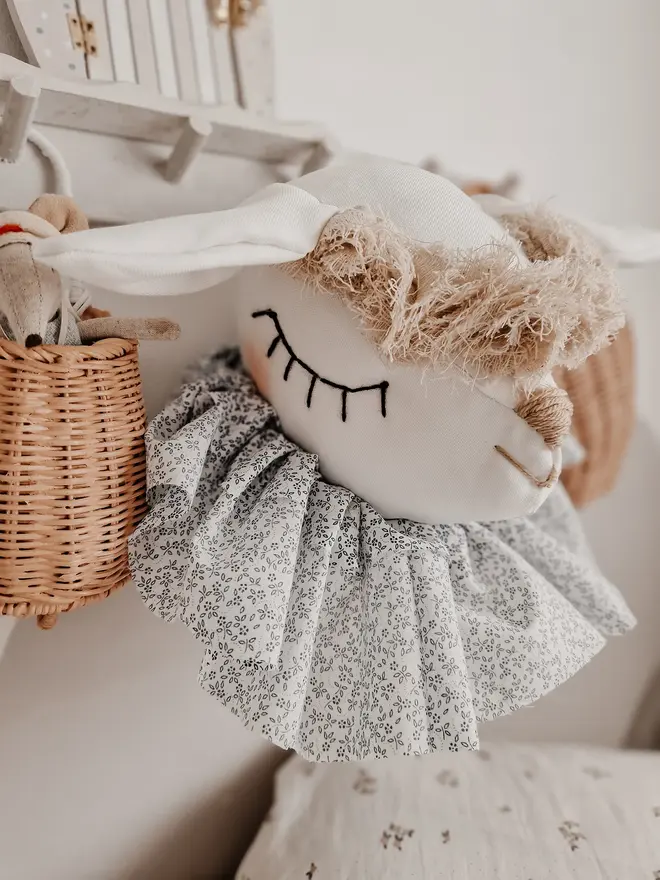 Sheep Head Wall Mount, a hanging sheep head decoration sitting against a plain wall in child's bedroom. 