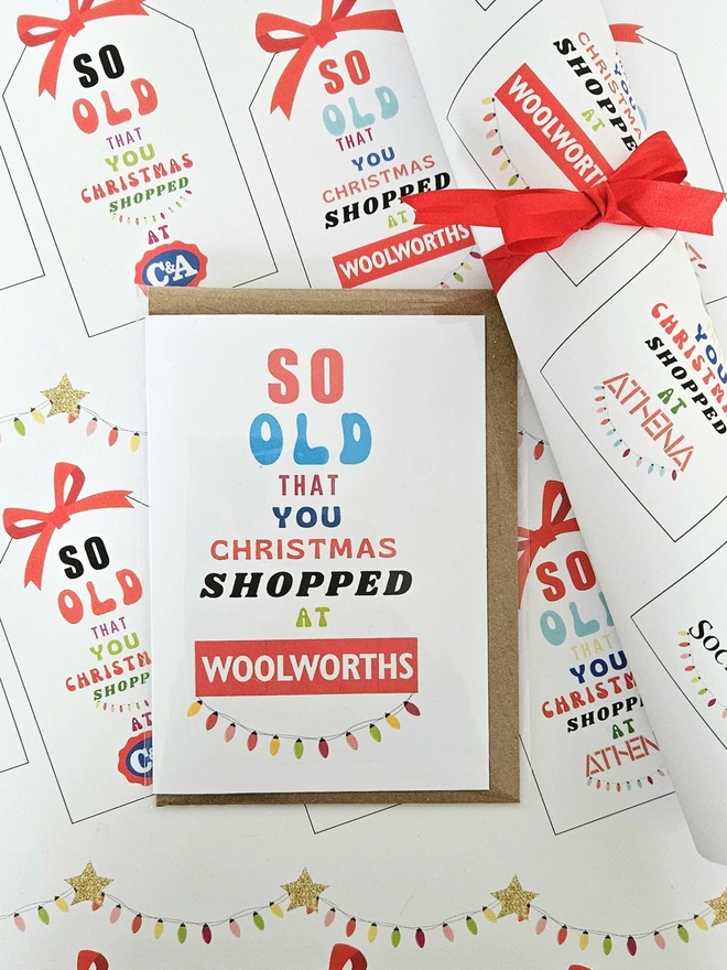 A close up photograph of the wrapping paper with tags that say so old you Christmas shopped at Woolworths, Tie Rack, C&A with a greeting card that says so old you  Christmas shopped at Woolworths.