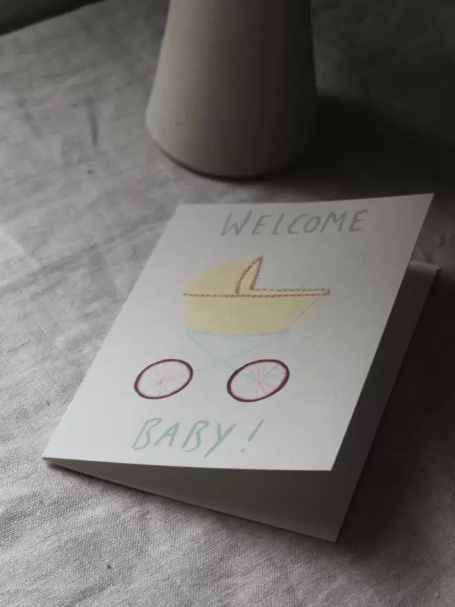 welcome baby card with a pram on the front