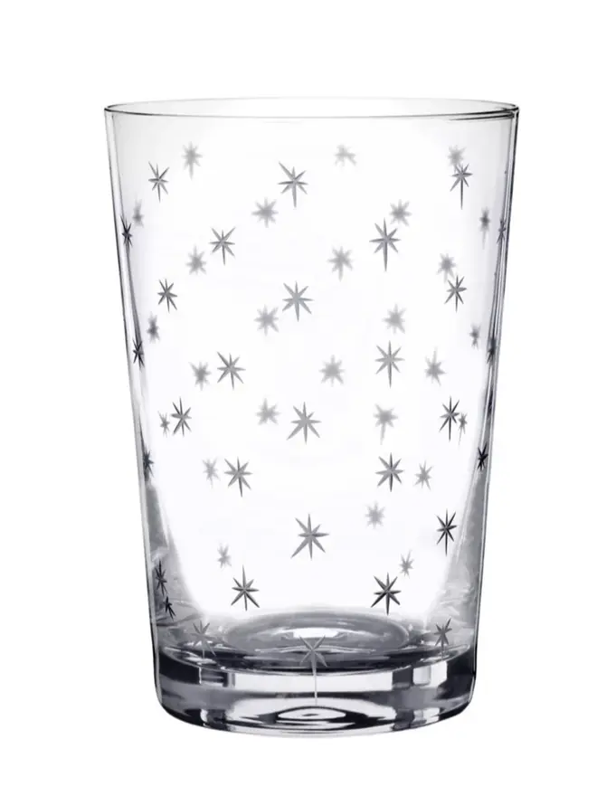 engraved stars crystal tumblers (set of 6). a tumbler glass patterned with small stars.