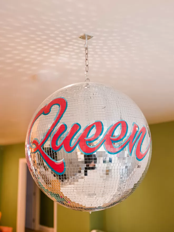 Third Eye Dancing Queen disco ball with dancing queen written in red around the ball seen in a kitchen.